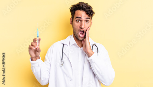 hispanic handsome man feeling shocked and scared physician and srynge concept photo