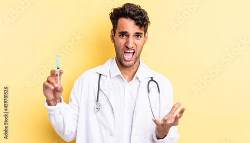 hispanic handsome man looking desperate, frustrated and stressed physician and srynge concept photo