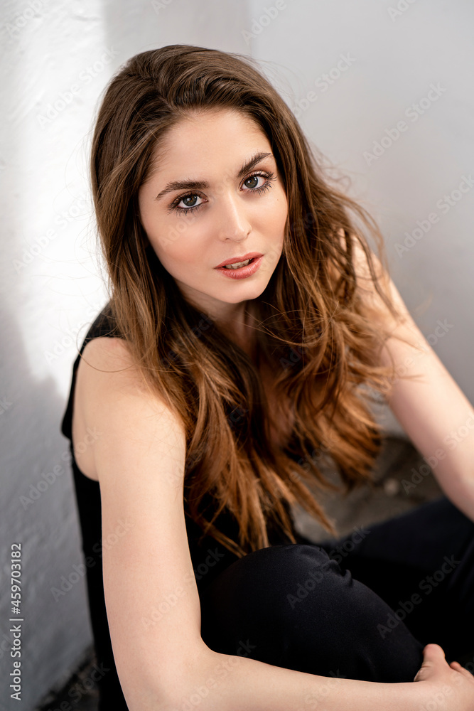 Beautiful woman with brown hair in front of wall Beautiful woman with brown hair in front of wall