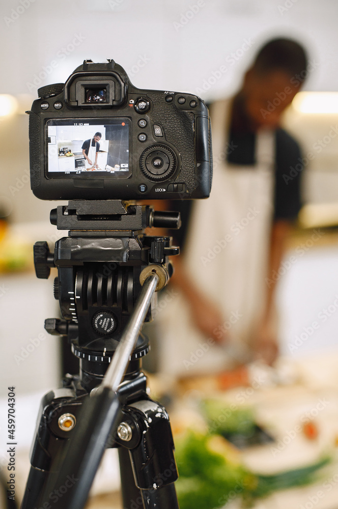 African male blogger recording vlog on digital camera