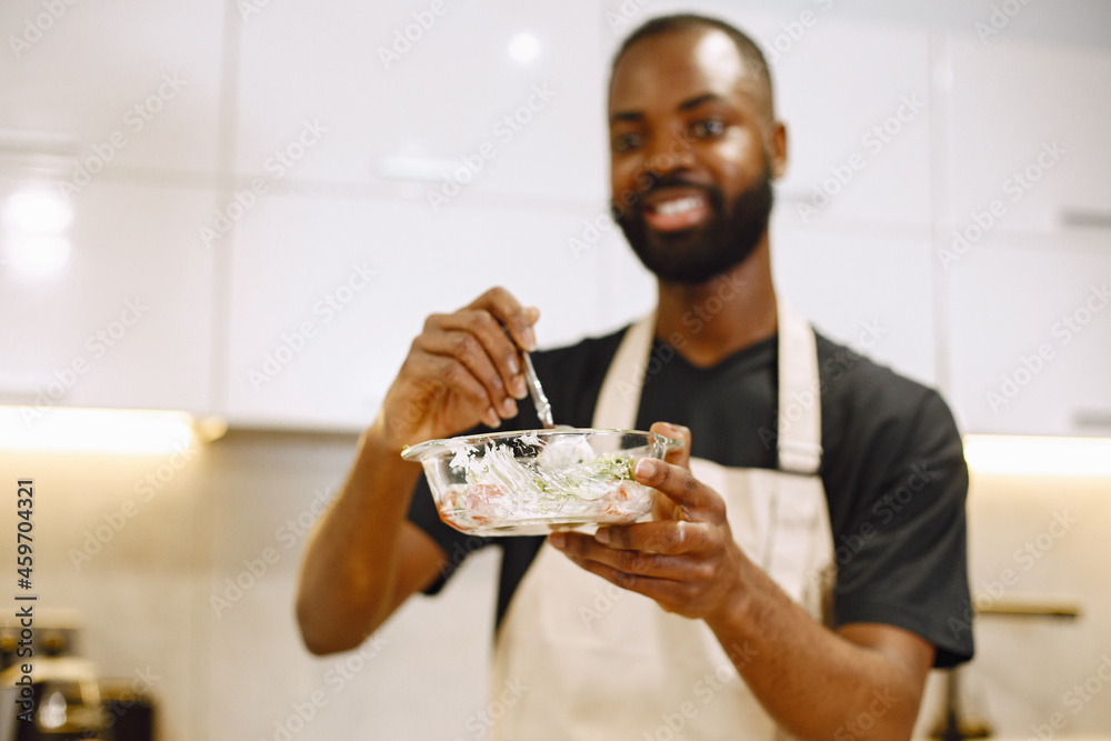 Confident african hipster man blogger recording vlog about cooking on digital camera stay in a kitchen Confident african hipster man blogger recording vlog about cooking on digital camera stay in a kitchen