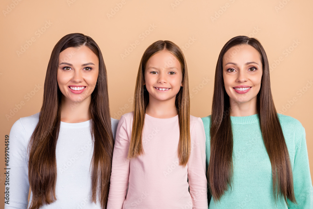 Portrait of three attractive cheerful brown-haired girls mommy daughter isolated over beige pastel color background Portrait of three attractive cheerful brown-haired girls mommy daughter isolated over beige pastel color background