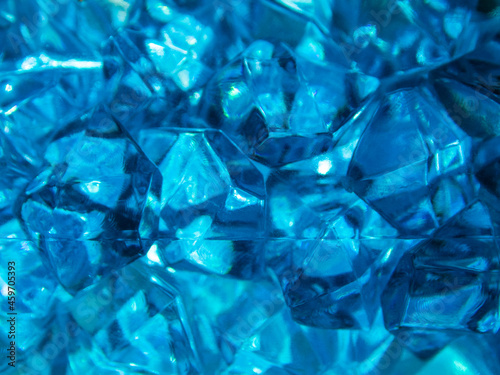 Bright blue crystals made of glass look like gems close-up in the blur. Background from blue stones crystals.
