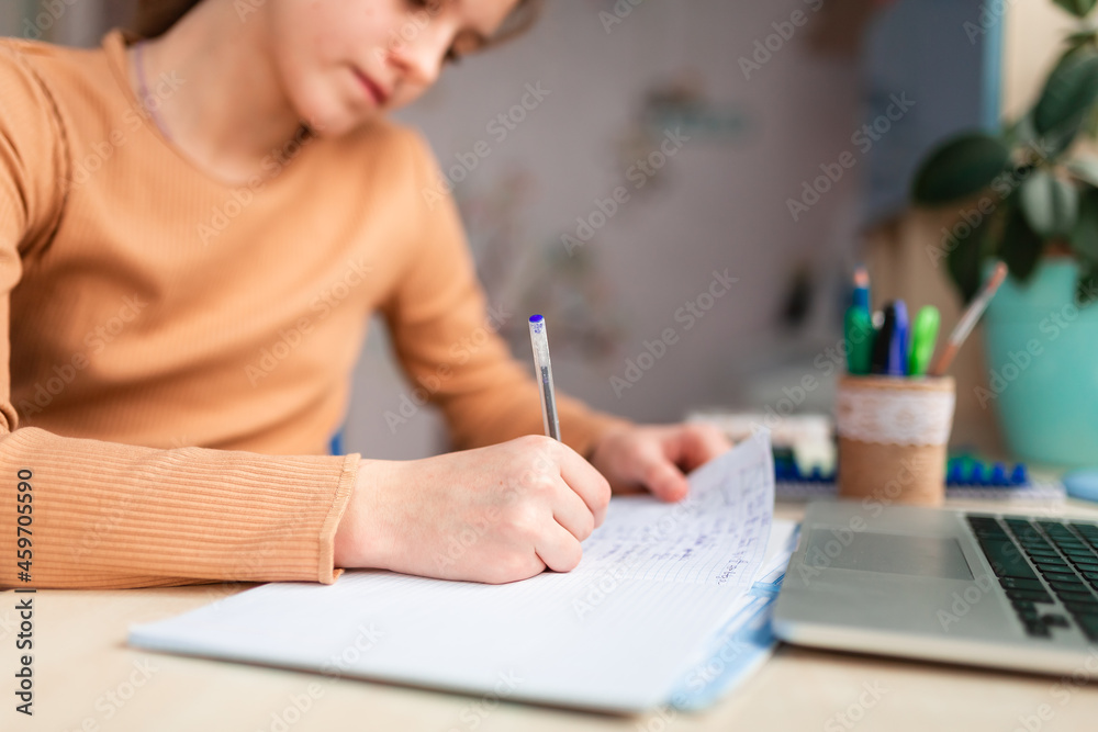 Beautiful schoolgirl studying at home doing school homework. Distance learning online education Beautiful schoolgirl studying at home doing school homework. Distance learning online education