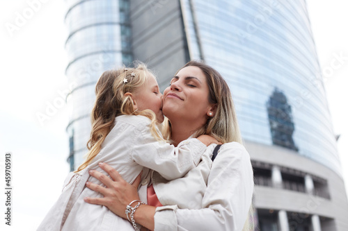 Mother and daughter laugh sincerely. Styling family, true emotions, good day in urban environment photo