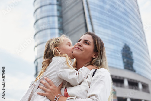 Mother and daughter laugh sincerely. Styling family, true emotions, good day in urban environment photo