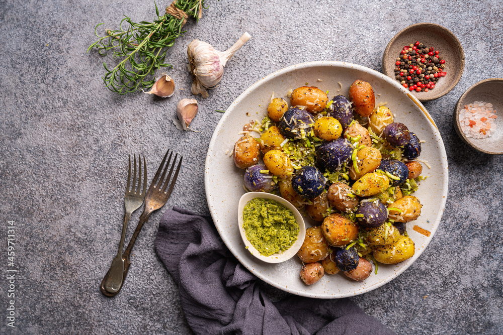 New roasted, baked baby potato on the plate with sauce, top view New roasted, baked baby potato on the plate with sauce, top view