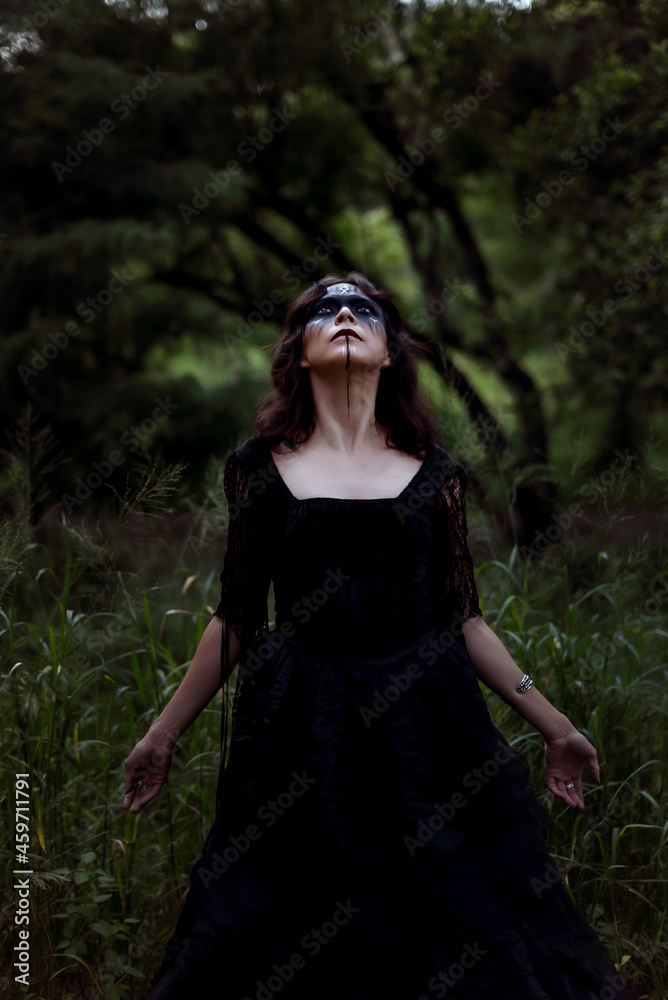 Witch in black dress in dark forest Witch in black dress in dark forest