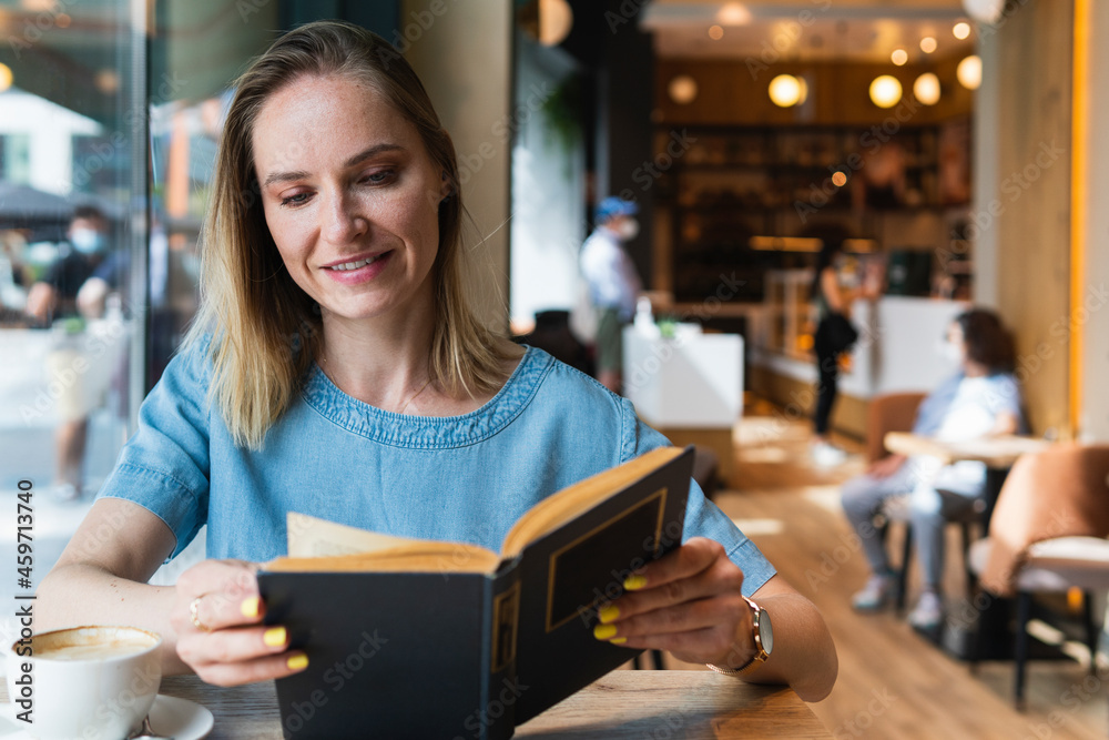 Blond businesswoman reading book at coffee shop Blond businesswoman reading book at coffee shop