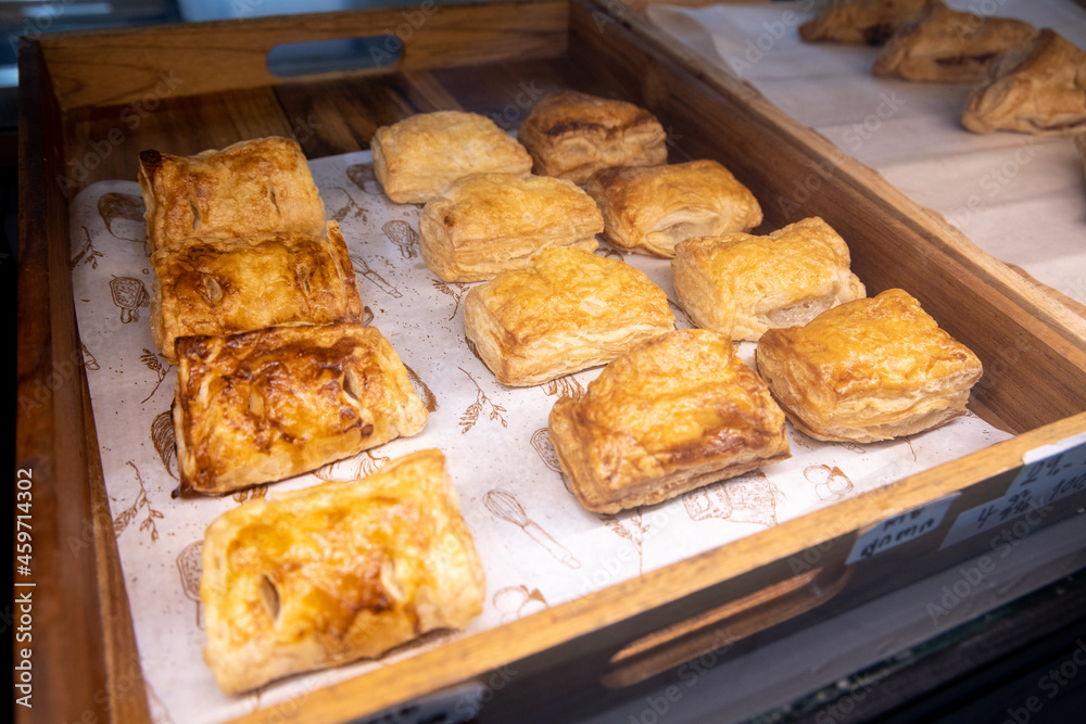 Baked puff pastry with toppings. Puffs with cheese on a wooden tray.