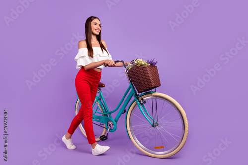 Profile photo of carefree dreamy lady ride bike wear white blouse pants sneakers isolated purple color background © deagreez