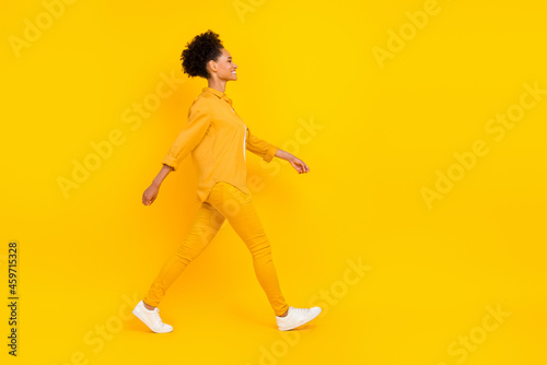 Full length body size photo woman smiling wslking on meeting isolated vivid yellow color background