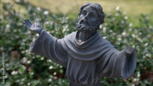 Statue of Saint Francis of Assisi in Garden On Sunny day With Parallax motion effect photo