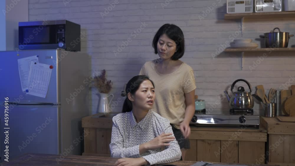 happy asian female worker is eating hot soup from the bowl at midnight after work in the dining room at home. happy asian female worker is eating hot soup from the bowl at midnight after work in the dining room at home.