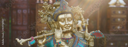 Panoramic photography of Hindu God Krishna. Statuette of Krishna playing the flute. Religious theme photo
