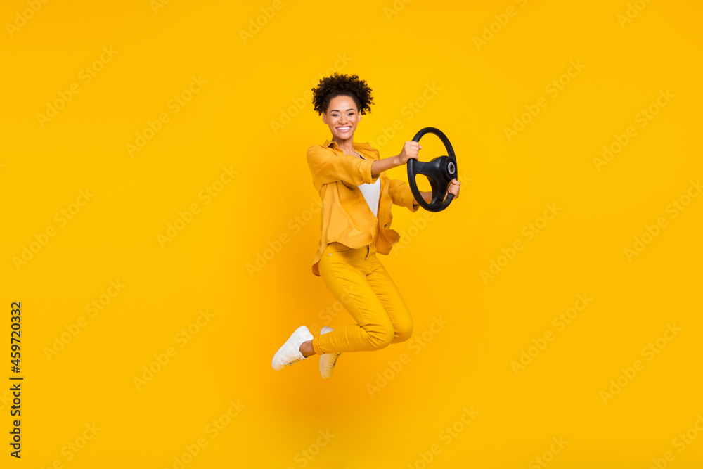 Full length body size photo woman jumping keeping steering wheel isolated vivid yellow color background - obrazy, fototapety, plakaty 