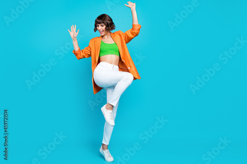 Full size photo of funny millennial brunette lady dance wear blazer top jeans shoes isolated on teal color background