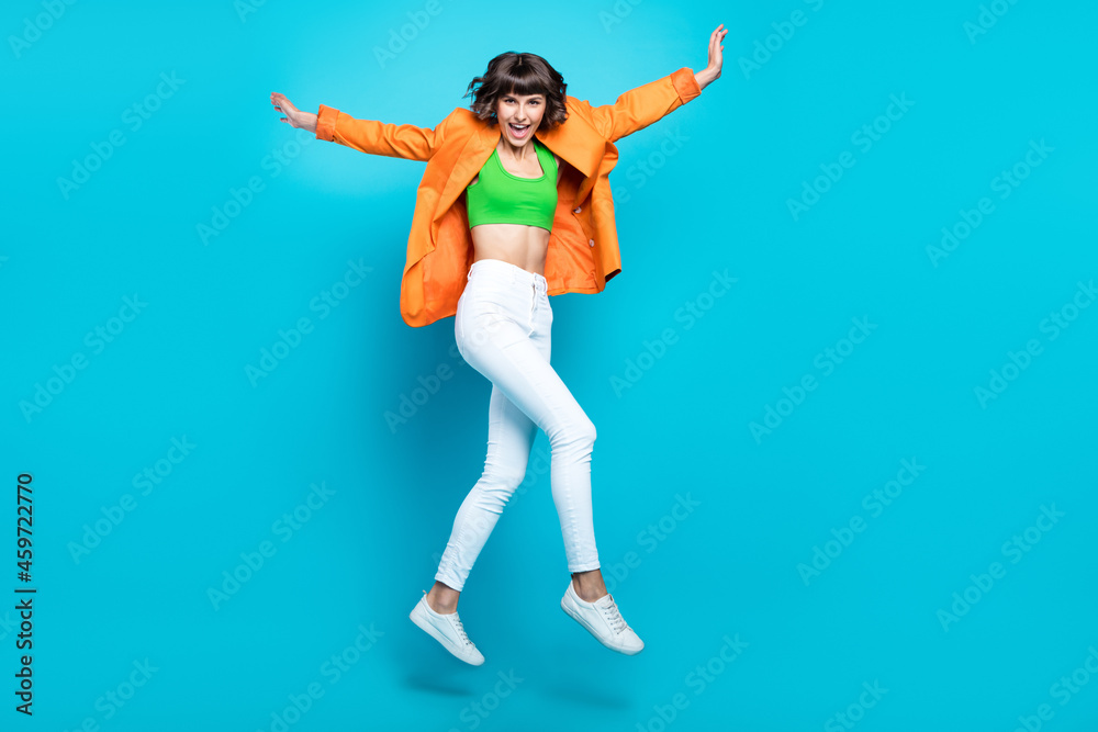 Full body photo of happy pretty nice woman jump up vacation enjoy smile isolated on blue color background