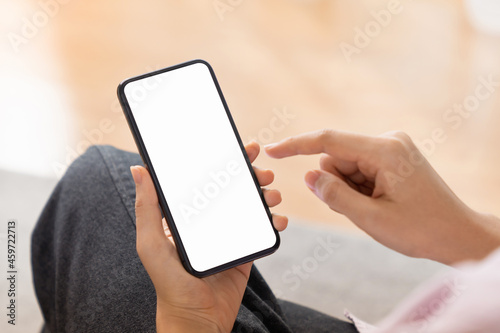 Close up of hand holding smartphone with white mock-up screen..