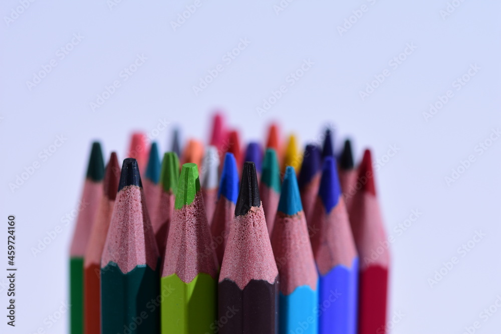 Multi-colored pencils sharpened on a white background, depth of field. Background. White. Multi-colored pencils sharpened on a white background, depth of field. Background. White.