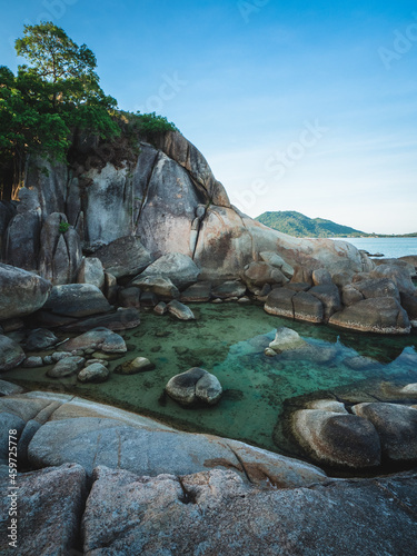 Scenic view of stunning rock formation cliff, rocky bay with hidden small lagoon, blue water against blue sky. Hin Ta Hin Yai, Lamai Beach, Koh Samui Island, Thailand.