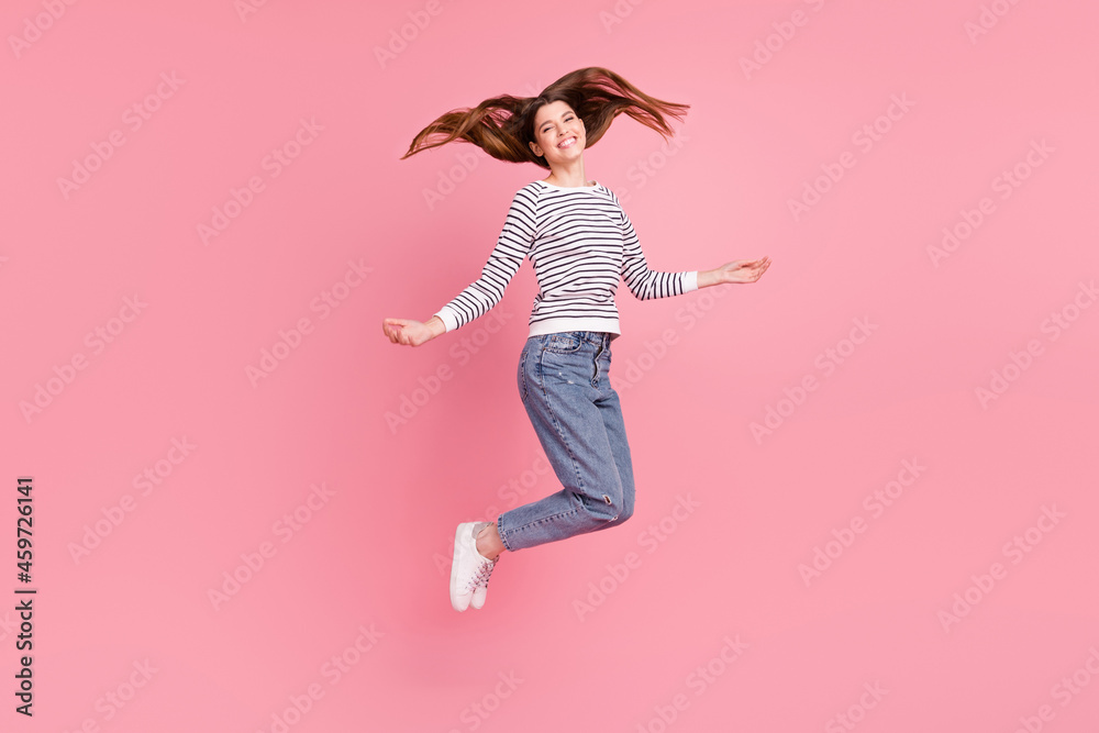 Full length body size view of attractive cheerful girl jumping enjoying rest isolated over pink pastel color background Full length body size view of attractive cheerful girl jumping enjoying rest isolated over pink pastel color background