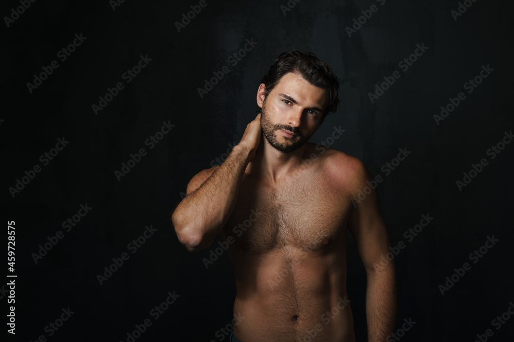 Young half-naked man posing and looking at camera
