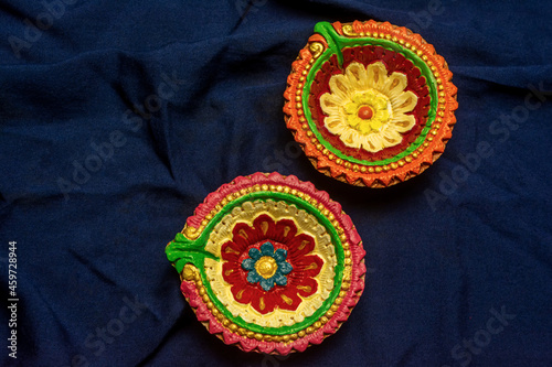 Happy Diwali - Colorful clay diya or oil lamps on blue background.
