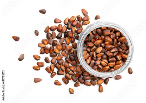 Glass bowl with pine nuts in shell isolated on white background. Top view, close up.