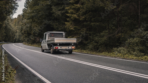 White truck is on mountain highway winding through forested landscape in autumn colors - business, commercial, cargo transportation concept, clear and blank space on the side view © Артем Крупецкий