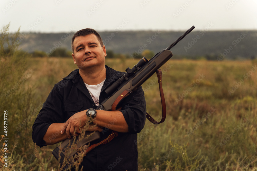 European shoots a rifle with a optics sight. Portrait of a shooter with a rifle European shoots a rifle with a optics sight. Portrait of a shooter with a rifle