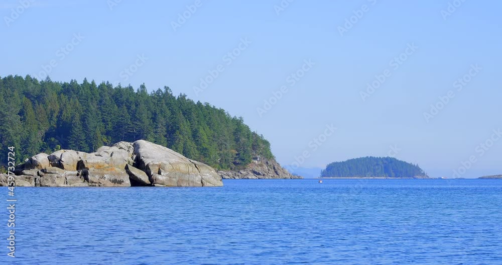 Establishing shot of ocean view with mountains, blue sky and white clouds in slow motion at summer day in Vancouver, Canada, North America. Day time on May 2021. Still camera. ProRes 422 HQ. Establishing shot of ocean view with mountains, blue sky and white clouds in slow motion at summer day in Vancouver, Canada, North America. Day time on May 2021. Still camera. ProRes 422 HQ.
