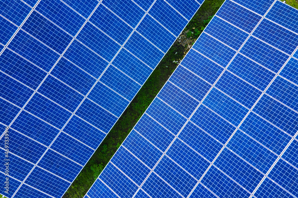 Aerial view of large sustainable electrical power plant with rows of solar photovoltaic panels for producing clean ecological electric energy. Renewable electricity with zero emission concept. Aerial view of large sustainable electrical power plant with rows of solar photovoltaic panels for producing clean ecological electric energy. Renewable electricity with zero emission concept.