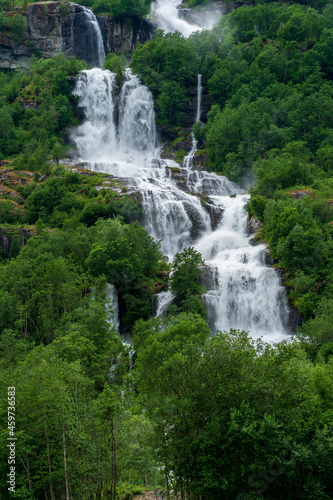 Waterfall in the green woods in spring time.