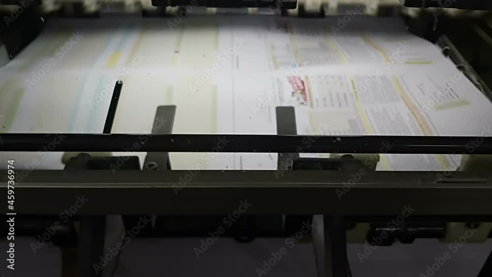 A modern four colour printing machine running in high speed. Shot at Kolkata, West Bengal, India. A modern four colour printing machine running in high speed. Shot at Kolkata, West Bengal, India.