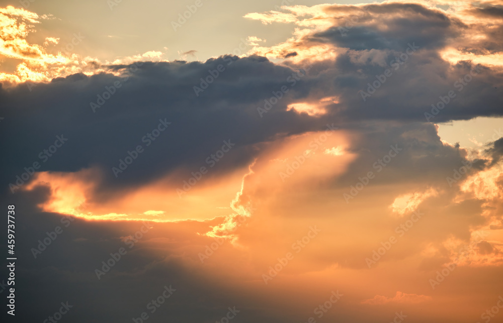 Bright landscape of dark clouds on yellow sunset sky in evening.