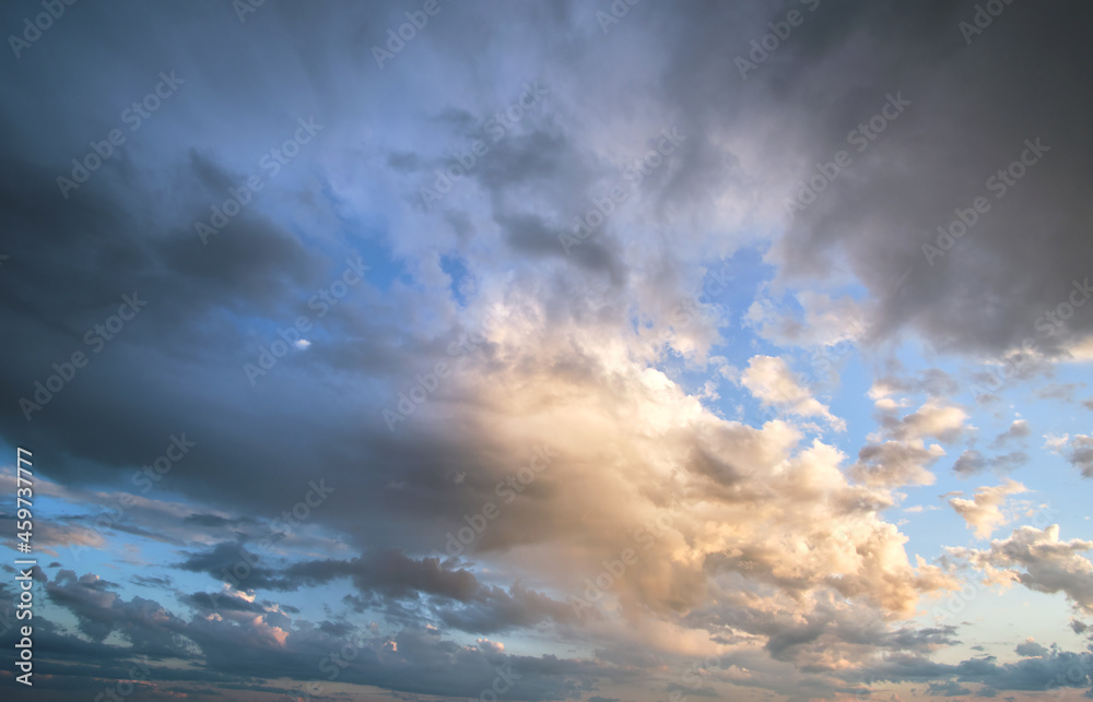 Obraz premium Bright landscape of dark clouds on yellow sunset sky in evening.