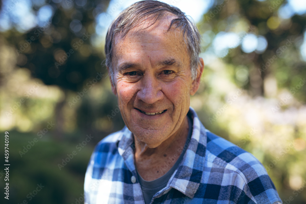 Portrait of happy caucasian senior man looking at camera in garden Portrait of happy caucasian senior man looking at camera in garden