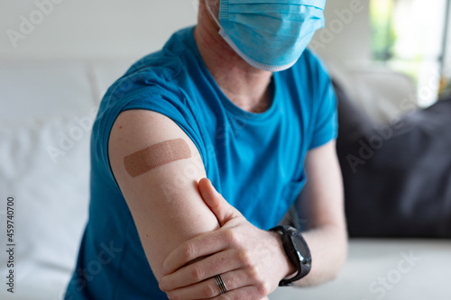 Closeup of african american albino man wearing a face mask with plaster after vaccination