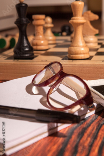 Glasses, a notebook and a lost chess game