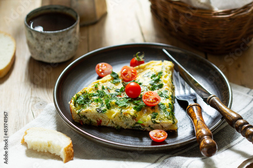Breakfast of omelet with vegetables, herbs and cheese, served with bread and coffee. photo