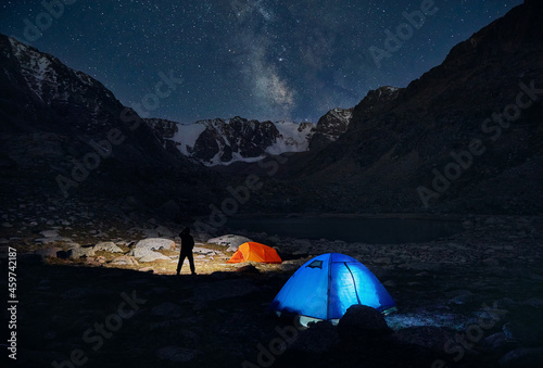 Glowing tent camping and man in the Night Mountains