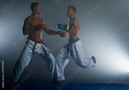 Two karate guys is practicing martial arts in sport gym