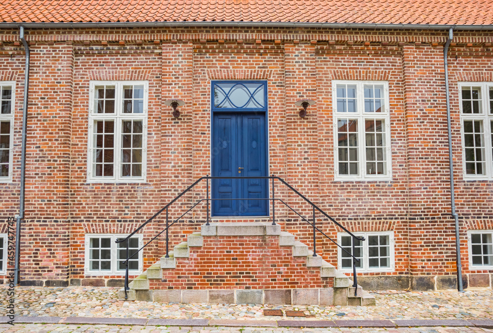 Steps and blue door of a historic red brick house in Viborg, Denmark