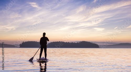 Adventurous Caucasian Adult Woman on a Stand Up Paddle Board is paddling on the West Coast of Pacific Ocean. Sunny Sunrise Sky Art Render. Victoria  Vancouver Island  BC  Canada.