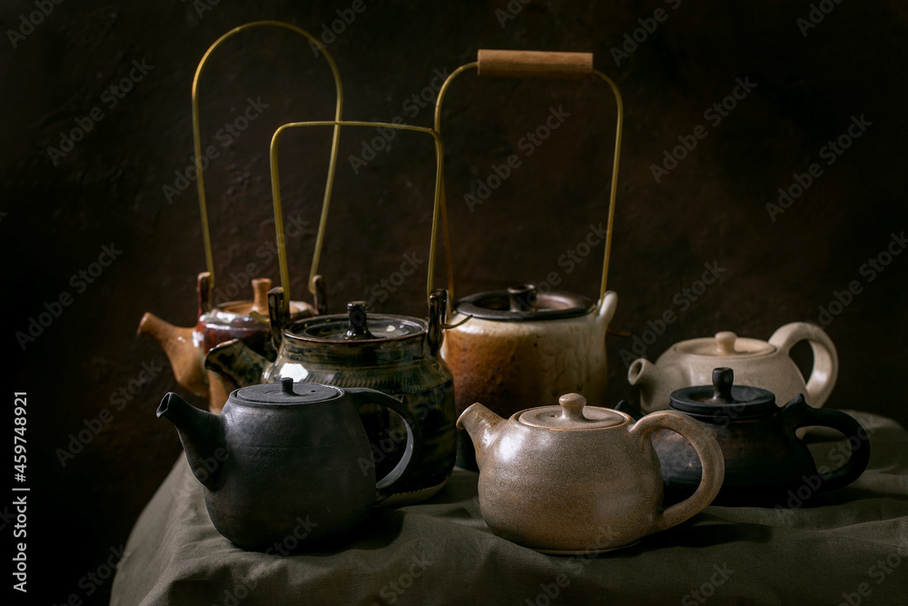 Set of craft handmade ceramic teapots with dark background