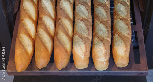 Several baguettes coming out of an old antique rustic oven