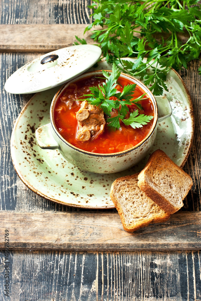 Vegetables soup with beetroot, carrot, cabbage and potatoes in bowl on wooden table Vegetables soup with beetroot, carrot, cabbage and potatoes in bowl on wooden table