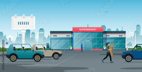 A woman brings her belongings to the parking lot after shopping at the supermarket.