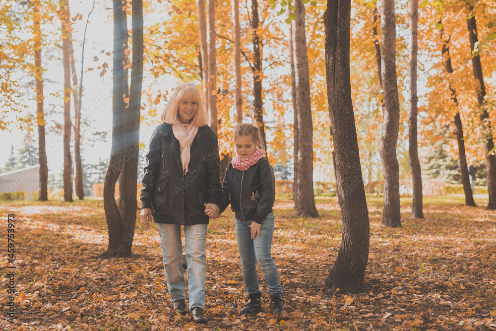 Grandmother with granddaughter in autumn park. Generation and family concept. Grandmother with granddaughter in autumn park. Generation and family concept.